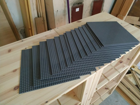 Grey LEGO construction plates fanned out on a shelf